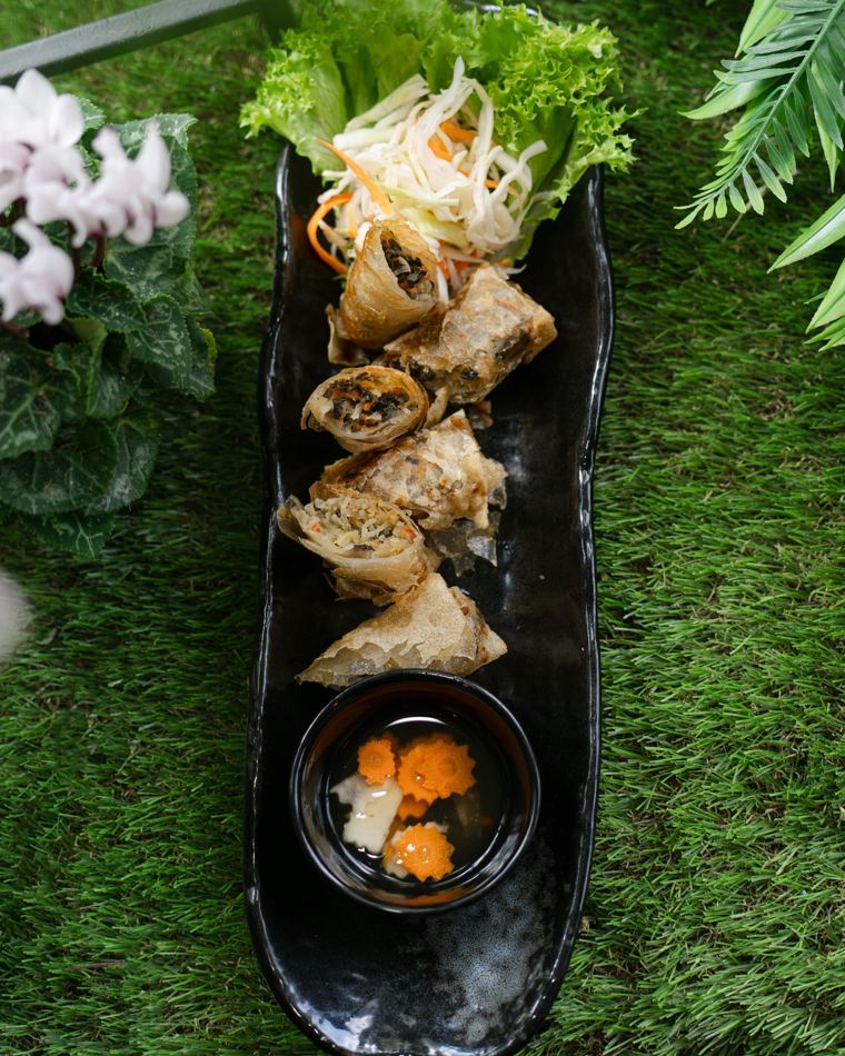 Knusprig frittierte Teigtaschen auf einer schwarzen Platte mit Dip